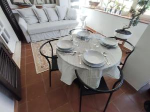 a white table with chairs and a white couch at Lara's Green Home in Quercianella