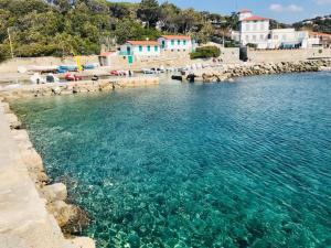 a beach with turquoise water and a group of buildings at Lara's Green Home in Quercianella