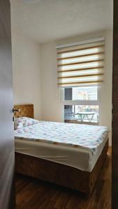 een slaapkamer met een bed en een raam met een blinde bij Prestige Bulevar Sarajevo in Sarajevo