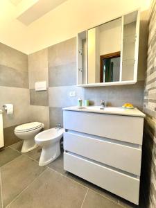 a bathroom with a sink and a toilet and a mirror at La Corte del Principe in Bracciano