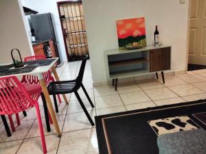 un soggiorno con tavolo, sedie e TV di Apartment on MR103 a Mbabane