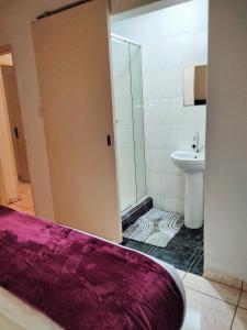 a bathroom with a shower and a toilet and a sink at Apartment on MR103 in Mbabane