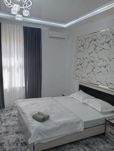 um quarto com uma cama com um quadro na parede em MAR.s em Bukhara