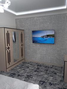 um quarto com uma cama e uma televisão na parede em MAR.s em Bukhara