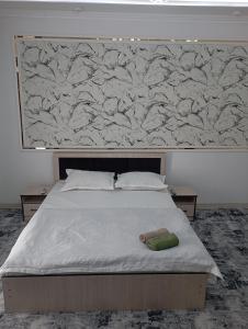 uma cama num quarto com uma grande parede em MAR.s em Bukhara