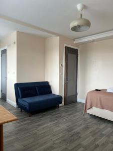 a living room with a blue couch and a bed at Boutique Apartments in London