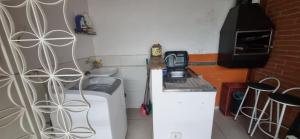 uma cozinha com um lavatório e uma máquina de lavar roupa em Chalé de Sampa em São Paulo