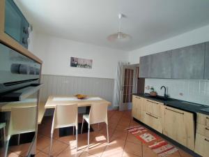 a kitchen with a table and some chairs in it at Appartamento Lido in Levico Terme