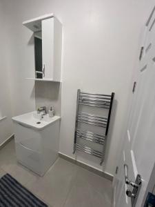 a white bathroom with a sink and a mirror at London rooms in London