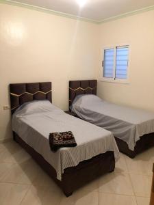 two beds in a room with a window at Residence al Rahma 03 in Monte ʼArrouit