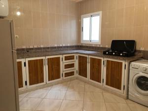 a kitchen with a sink and a washer and dryer at Residence al Rahma Airport nr 03 in Monte ʼArrouit