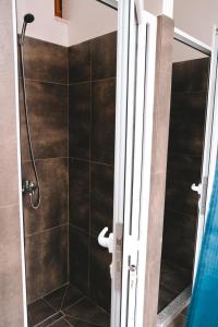 bagno con doccia e porta in vetro di Scodrinon Hostel a Shkodër