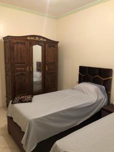 a bedroom with two beds and a mirror at Residence al Rahma 03 in Monte ʼArrouit