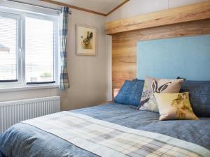 a bedroom with a bed with a wooden headboard at Beaumont Lodge in Plumbland