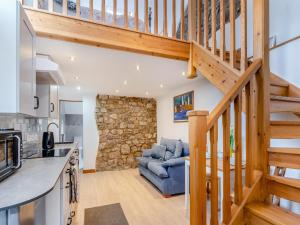 a kitchen and living room with a staircase and a couch at Bumpers Stable in Derwydd