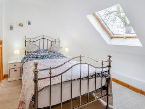 Schlafzimmer mit einem Bett und einem Fenster in der Unterkunft Bumpers Stable in Derwydd