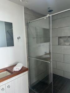 uma cabina de duche em vidro na casa de banho com um lavatório em Travesía Quindiana em Filandia