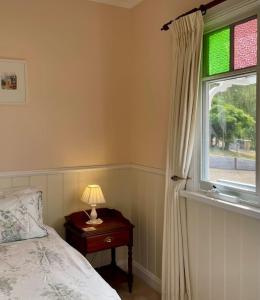 une chambre avec un lit et une fenêtre dans l'établissement Maple Hill Cottage, à Castle Forbes Bay