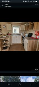 a small kitchen with white cabinets and a window at Oakley in Rookley