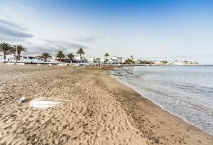 una spiaggia con tavola da surf sdraiata sulla sabbia di Luxury Apartment Chalana a Playa Honda