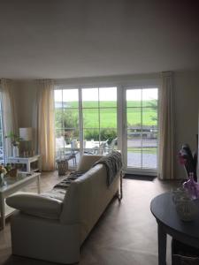 een woonkamer met een witte bank en een tafel bij Nieuwe Beachbungalow aan IJsselmeer 39 24 four seasons in Lemmer