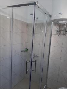 a shower with a glass door in a bathroom at Vangert Apartment in Berat