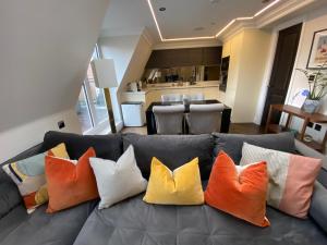 a couch with colorful pillows on it in a living room at Beautiful Penthouse in centre of Winchester in Winchester