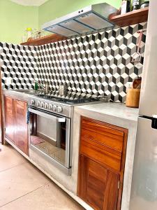 eine Küche mit einem Edelstahlherd und schwarzen und weißen Fliesen in der Unterkunft Sweet home Ixtapa comfort in Ixtapa