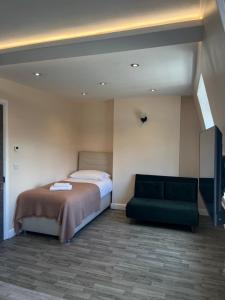 a bedroom with a bed and a green couch at The Lily Aparts in London