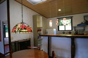 una cocina con mesa y una lámpara de araña con vidrieras. en Casa de Campo en la Montaña Negra-Subachoque, en Subachoque