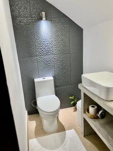 uma casa de banho com um WC branco e um lavatório. em Sweet home Ixtapa comfort em Ixtapa