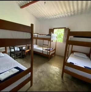 a room with several bunk beds and a window at Pousada Serra do Camulengo in Barra da Estiva