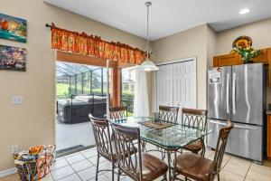 a kitchen with a table and chairs and a refrigerator at Be-Our-Guest Home! 15 mins to Disney! in Kissimmee