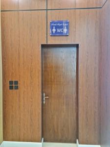 una puerta de madera con un cartel en la parte superior en فندق روزميلون en Al Fayşalīyah