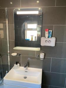 La salle de bains est pourvue d'un lavabo et d'un miroir. dans l'établissement Cosy Semi-Detached House To Stay In West Yorkshire, à Heckmondwike