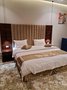 a bedroom with a large bed with a large headboard at فندق روزميلون in Sakakah +155 photos