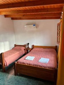 2 camas en una habitación con techos de madera en El Roble en Merlo