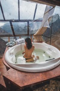 a woman sitting in a bath tub with a view at Vertical Sky Luxury Suites in Ollantaytambo