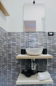 uma casa de banho com um lavatório e uma parede em azulejo em Genova Suite em Génova