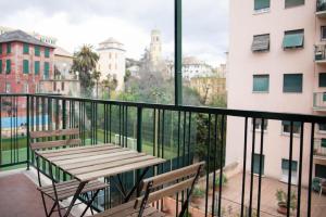 a balcony with a wooden table and two chairs at Genova Suite in Genoa