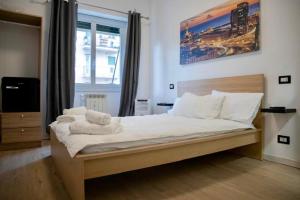 um quarto com uma cama com lençóis brancos e almofadas em Genova Suite em Génova