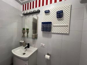 a white bathroom with a sink and a mirror at Civico 24 - apartment in Sorrento city center in Sorrento