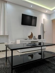 a living room with a black table and a tv on a wall at Top Belgrade Apartments in Belgrade