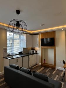 a living room with a couch and a kitchen at The Lily Aparts in London