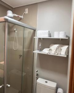 een badkamer met een douche, een toilet en handdoeken bij Studio Prime Designer Recife in Recife
