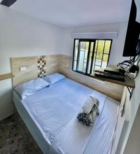 Bett in einem Zimmer mit Fenster und Tastatur in der Unterkunft Nativos Hospedaje in Medellín