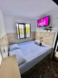 a bedroom with a large bed with a tv on the wall at Nativos Hospedaje in Medellín