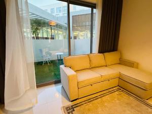 un soggiorno con divano e finestra di Luxurious studio apartment with private garden a Sharjah