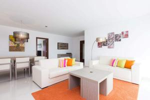 una sala de estar con 2 sofás blancos y una mesa. en D Wan Deluxe Apartments, en Baleal