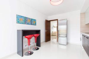 a living room with a fireplace and a red stool at D Wan Deluxe Apartments in Baleal
